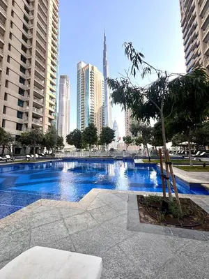 a large swimming pool in a city with tall buildings at Luxury One Bedroom Apartment with Fountain View opposite Dubai Mall in Dubai