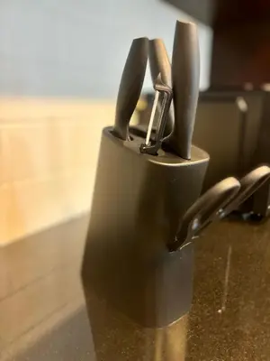 a cup with knives in it on a counter at Luxury One Bedroom Apartment with Fountain View opposite Dubai Mall in Dubai