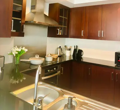 a kitchen with wooden cabinets and a sink at Luxury One Bedroom Apartment with Fountain View opposite Dubai Mall in Dubai