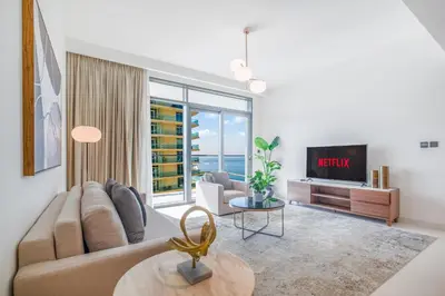 a living room with a couch and a tv at LUX The Marina Vista Beachfront Suite 4 in Dubai