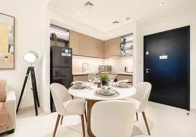 a kitchen with a table and chairs and a refrigerator at Stylish Downtown Retreat, Burj Crown, Opera & Boulevard View in Dubai