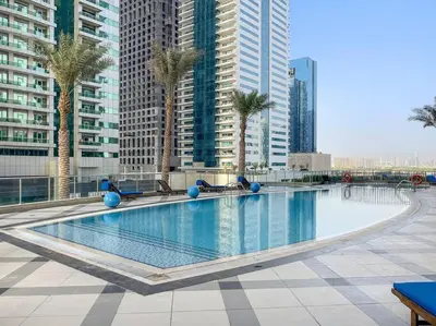a large swimming pool with palm trees in a city at Luxury 2BRin Torch Tower with Dubai Marina Skyline Views in Dubai