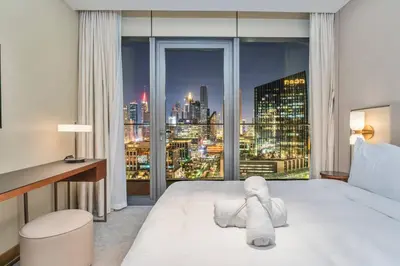 a bedroom with a large window with a city skyline at Family 3BR Flat Free Parking, Gym, Pool & Burj Views in Dubai