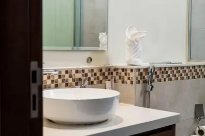 a bathroom with a white sink and a mirror at FIRST CLASS 2BR Luxury Urban Escape in Dubai