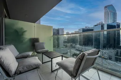 a balcony with chairs and a view of a city at FIRST CLASS 2BR Luxury Urban Escape in Dubai