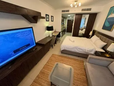 a bedroom with a bed and a large flat screen tv at Stunning Apartment - High Floor - Canal View in Dubai