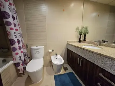 a bathroom with a toilet and a sink and a mirror at Stunning Apartment - High Floor - Canal View in Dubai