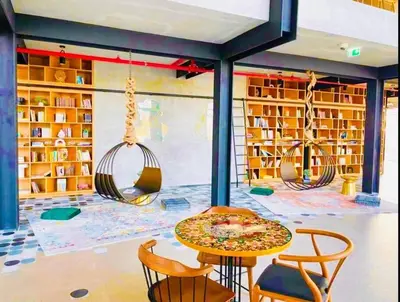 a library with a table and chairs and swings at Dubai Hills estate - 1Bedroom Apt in Dubai