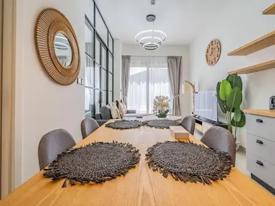 a dining room with a wooden table with chairs at Dubai Hills estate - 1Bedroom Apt in Dubai