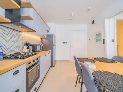 a kitchen with a table and a stove top oven at Dubai Hills estate - 1Bedroom Apt in Dubai