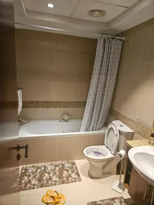 a bathroom with a tub and a toilet and a sink at Fairways north in Dubai