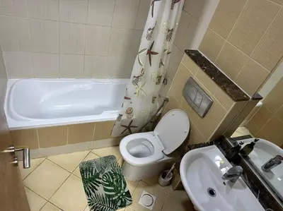 a bathroom with a toilet and a sink and a tub at Beautiful Studio Apartment in Dubai