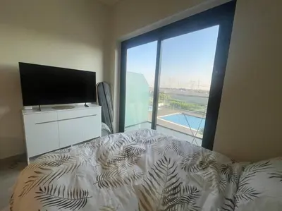 a bedroom with a bed and a television and a large window at The Perfect Couples Nest in Dubai