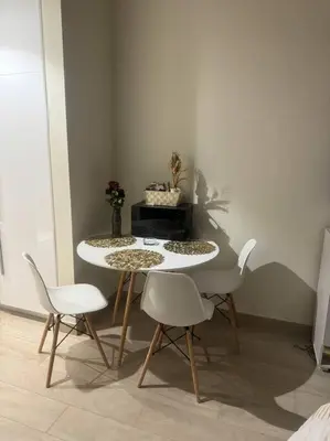 a dining room with a table and white chairs at The Perfect Couples Nest in Dubai
