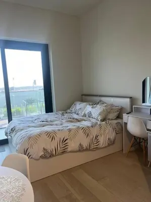 a bedroom with a bed and a desk and a window at The Perfect Couples Nest in Dubai