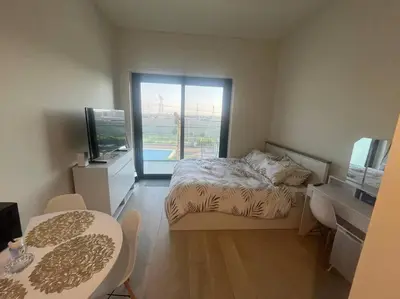 a bedroom with a bed and a television and a table at The Perfect Couples Nest in Dubai