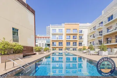 a swimming pool in front of a building at Cozy Modern Studio Oxford Residence in Dubai