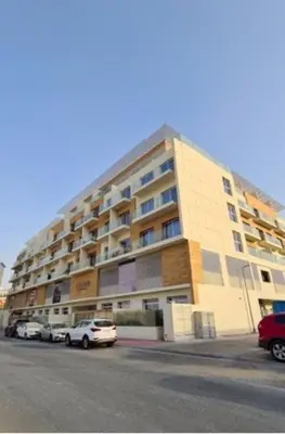 a large building with cars parked in front of it at Cozy Modern Studio Oxford Residence in Dubai