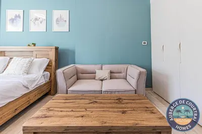 a bedroom with a bed and a chair and a couch at Cozy Modern Studio Oxford Residence in Dubai