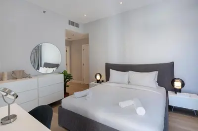 a bedroom with a white bed and a mirror at Al Andalus Tower F, Cadiz JGE - 3BR Apartment - Allsopp & Allsopp in Dubai