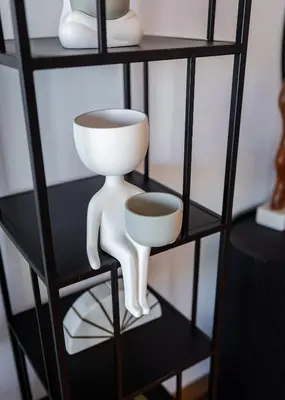 a shelf with a person holding a bowl and aucer at EDEN'S Homes & Villas - VIDA Dubai Marina Residences in Dubai