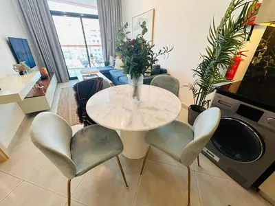 a living room with a table with a vase of flowers at Comfy 1br In Al Jaddaf Balcony Parking in Dubai