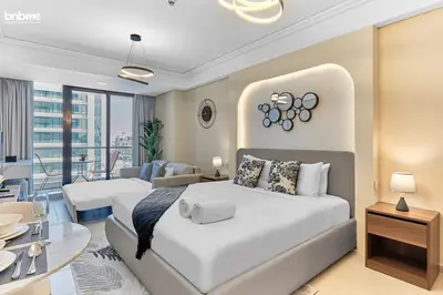 a bedroom with two beds and a dining room at bnbme - Stylish JLT Studio Near Metro Rooftop Pool Gym Balcony Marina Access in Dubai