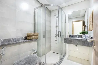 a bathroom with a glass shower and a sink at Nicely Furnished Home in the Heart of Business Bay in Dubai