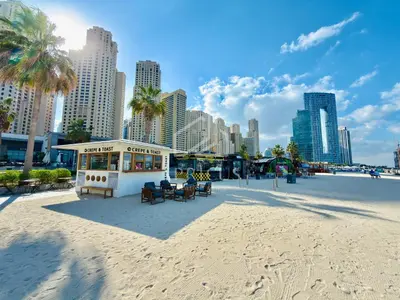 a building on the beach with a city in the background at Stylish 1BR apartment in Address Beach Residence in Dubai