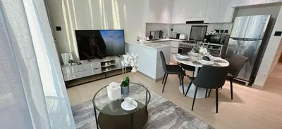 a kitchen and dining room with a table and chairs at Sleek 1br In Jvc Free Parking Pool & Balcony in Dubai