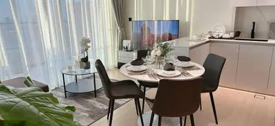a dining room with a table and chairs in a kitchen at Sleek 1br In Jvc Free Parking Pool & Balcony in Dubai