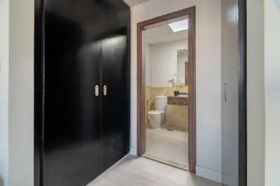 a hallway with a black door and a bathroom at GuestReady - Beachfront delight in JBR in Dubai