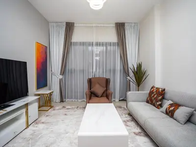 a living room with a couch and a tv at Elgant 2 bedroom in Dubai