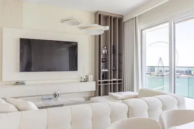 a living room with a white couch and a tv at Luxury Coastal Escape - Bright 3BR Apt - La Vie JBR in Dubai