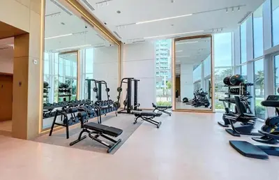 a gym with a lot of treadmills and machines at Luxury Coastal Escape - Bright 3BR Apt - La Vie JBR in Dubai