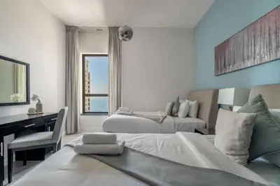 a bedroom with two beds and a desk and a desk at GuestReady - Charming retreat in Dubai Marina in Dubai