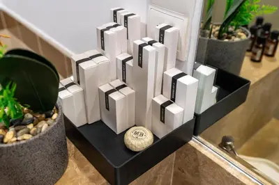 a white sculpture in a black holder next to a plant at Lux BnB I 29 Blvd I Burj Khalifa & Fountain Views in Dubai