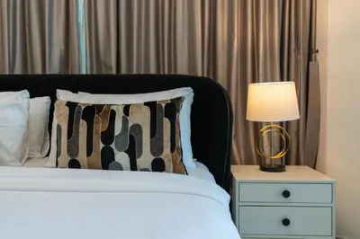 a bedroom with a bed with a lamp on a night stand at Lux BnB I 29 Blvd I Burj Khalifa & Fountain Views in Dubai