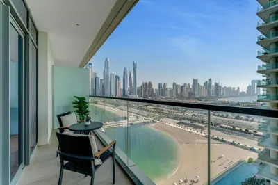 a balcony with a view of the beach and buildings at Coastal Chic 1 Bedroom Apartment w private beach in Dubai