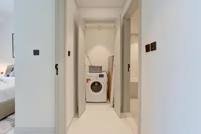a hallway with a washing machine in a room at Coastal Chic 1 Bedroom Apartment w private beach in Dubai