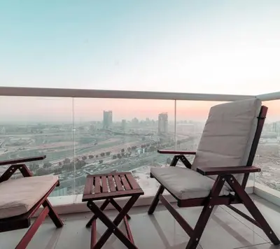 two chairs and a table on a balcony with a view at Comfortable Fully Furnished Studio l Ideal Living Space in Dubai