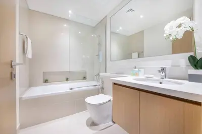a bathroom with a toilet and a tub and a sink at Luxury 42-Floor 1BR flat in Harbour Views in Dubai