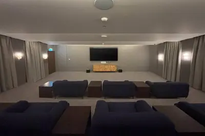 a large room with a stage with chairs and a flat screen tv at Frank Porter - Forte Tower 1 in Dubai