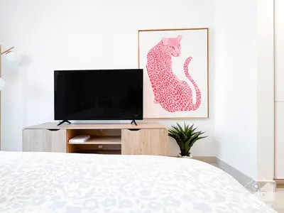 a bedroom with a tv and a painting of a cat at Urban Charm Studio with Balcony in Riviera in Dubai