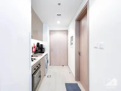 a kitchen with white walls and a door to a hallway at Urban Charm Studio with Balcony in Riviera in Dubai