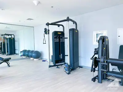 a gym with a row of treadmills and machines at Urban Charm Studio with Balcony in Riviera in Dubai