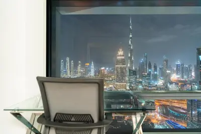 a laptop computer sitting on a desk in front of a window at Skyline Burj Facing Suite in Dubai