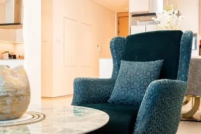 a living room with a blue chair and a table at Panoramic Sea & Palm Views 2BR Address Beach Resort JBR in Dubai