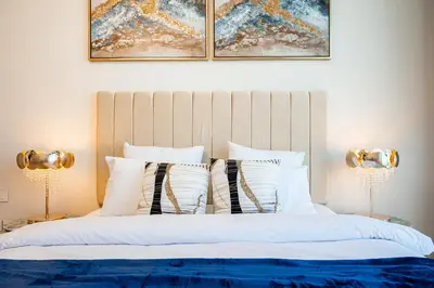 a bedroom with a bed with white pillows and two lamps at Panoramic Sea & Palm Views 2BR Address Beach Resort JBR in Dubai