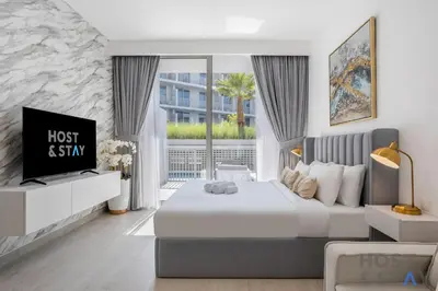 a bedroom with a bed and a tv in it at Charming Studio in Luma 22, Jumeirah Village Circle in Dubai